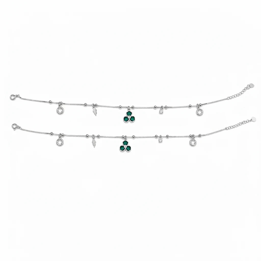 Shyni Jewelry silver charm anklet featuring a green clover pendant, small clear crystals, and delicate metal charms.