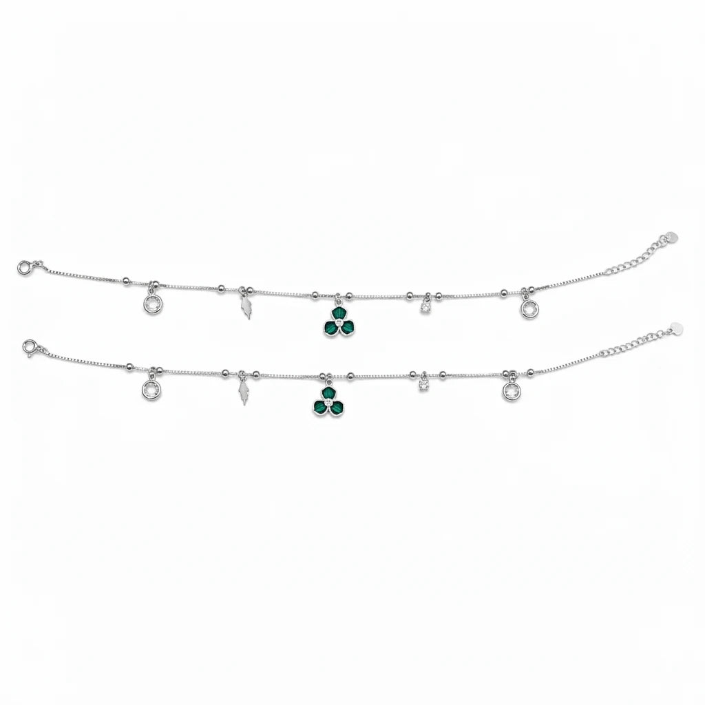 Shyni Jewelry silver charm anklet featuring green clover-shaped stones, clear crystals, and delicate metal charms.