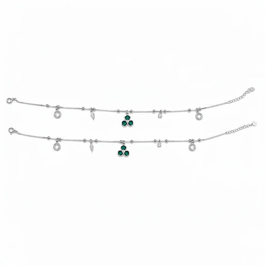 Shyni Jewelry silver charm anklet featuring green clover-shaped stones, clear crystals, and delicate metal charms.