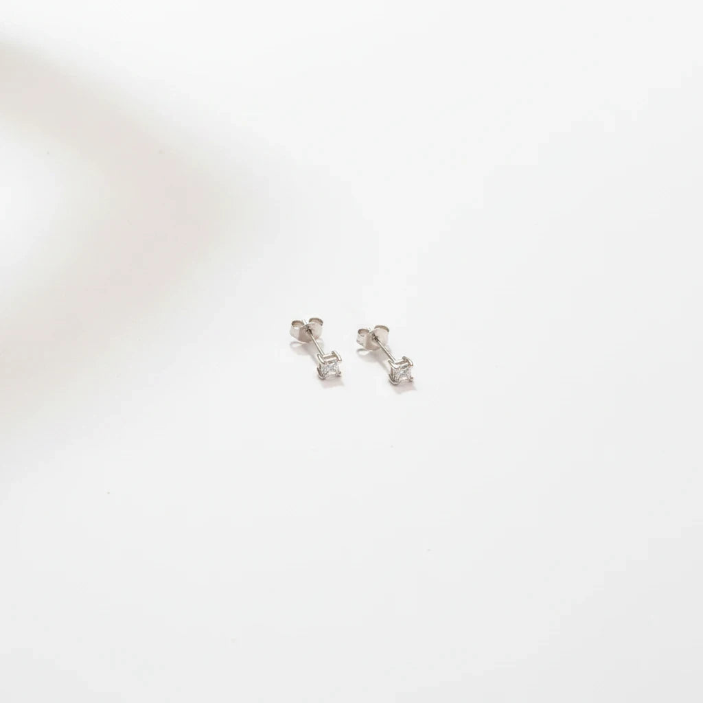 Shyni Jewelry square-shaped silver stud earrings with a single clear stone on a minimalist white background