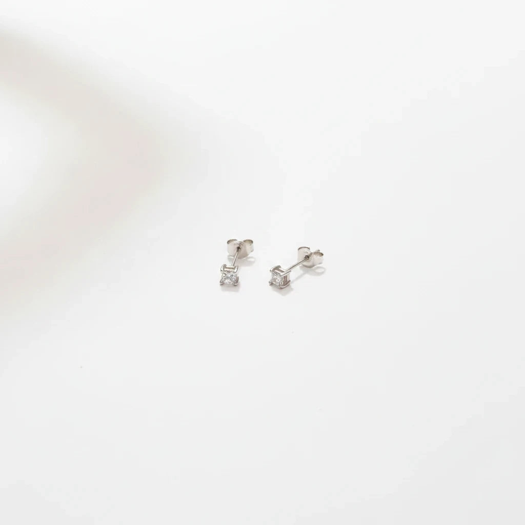 Shyni Jewelry square-cut stud earrings in silver with clear sparkling stones on a clean white background